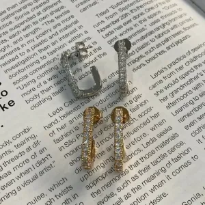 Brinco meia argola cravejada em zirconias