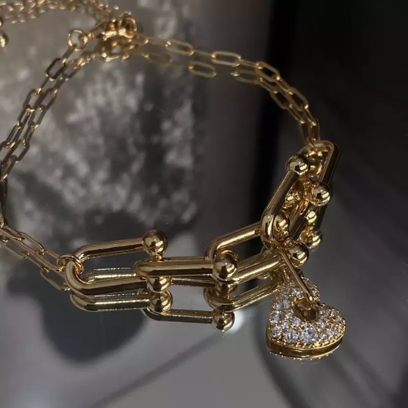 Pulseira de elos com pingente de coração cravejado.