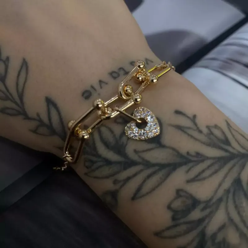 Pulseira de elos com pingente de coração cravejado.